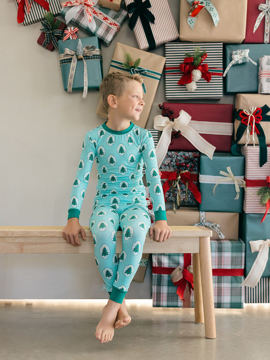 An older boy wearing green starry tree bamboo pajamas