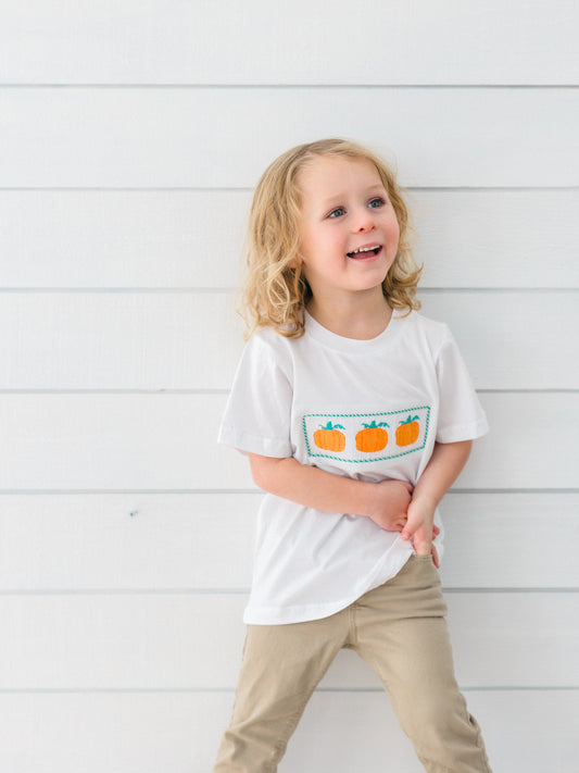 a little boy wearing a smocked pumpkin t-shirt 