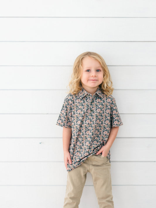 a little boy wearing a camo duck themed polo for duck days, fall and hunting