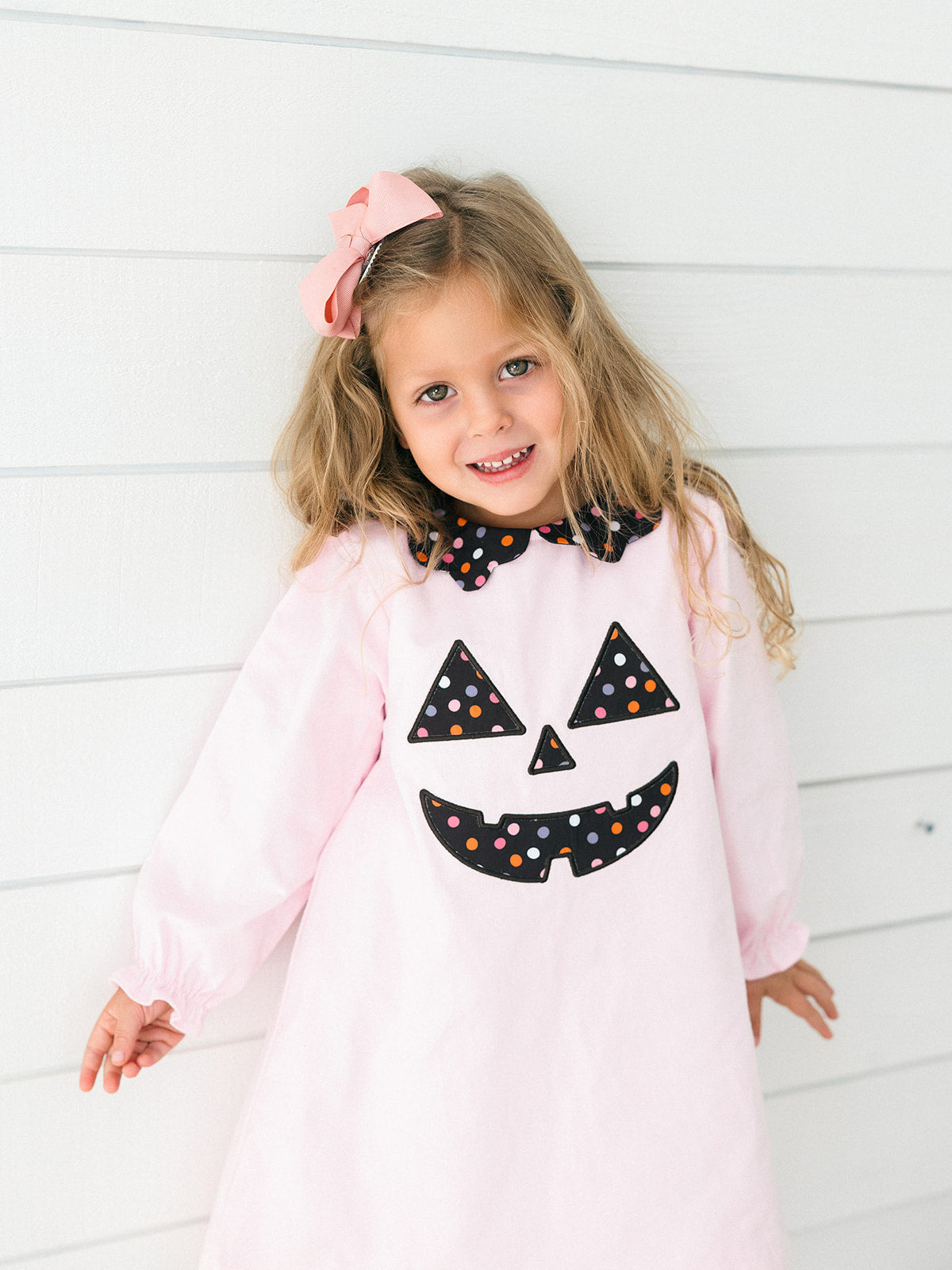 a young girl wearing the pink Jack-O-Lantern Dress 