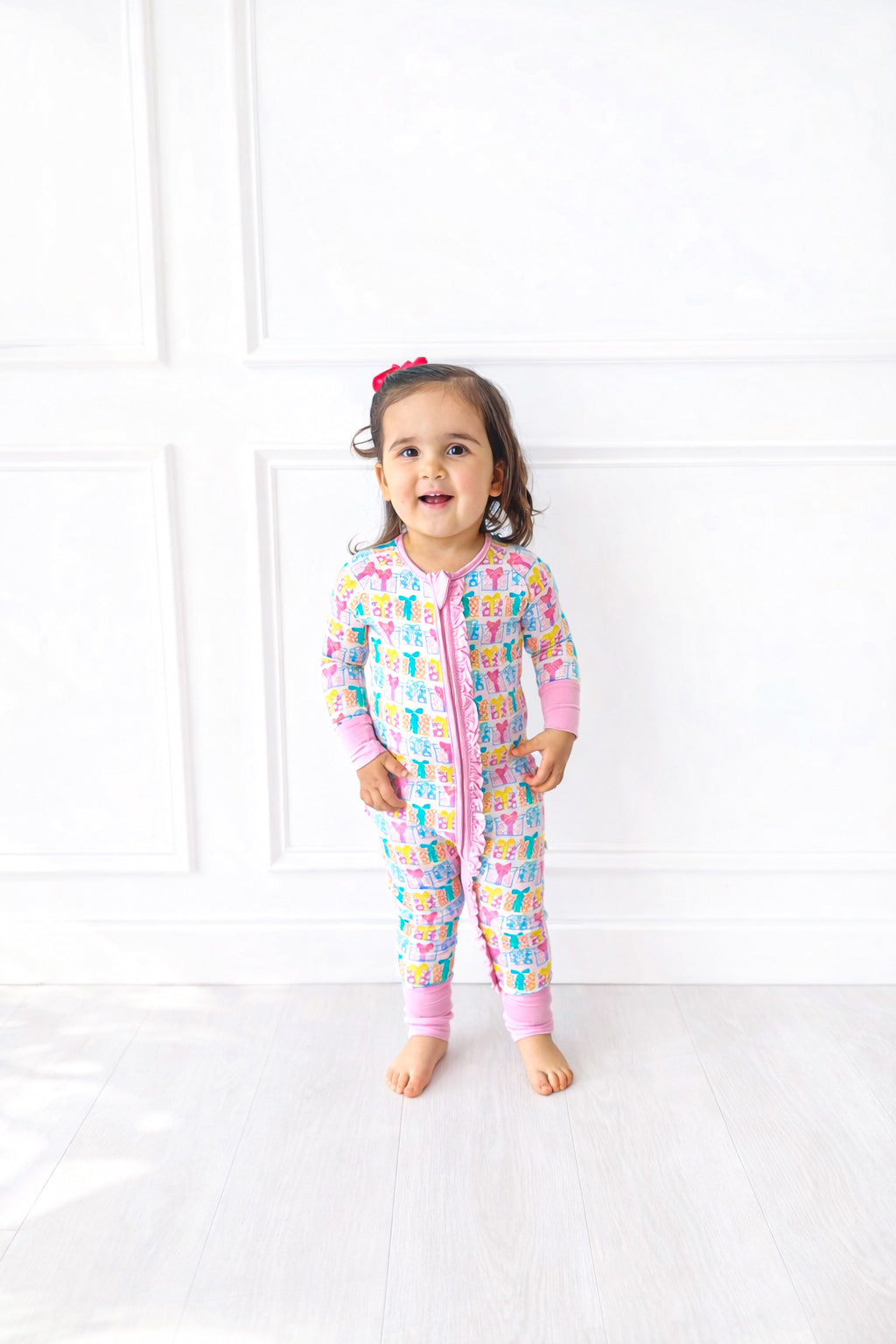 Child wearing a colorful presentonesie with a white background