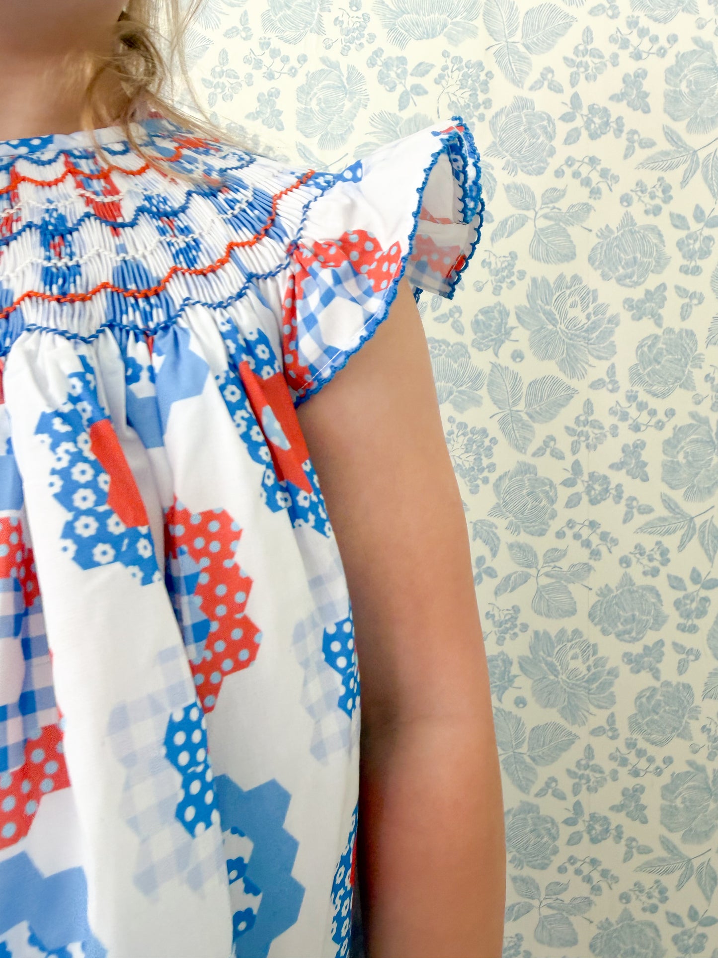 close up details of a red white and blue hand smocked dress