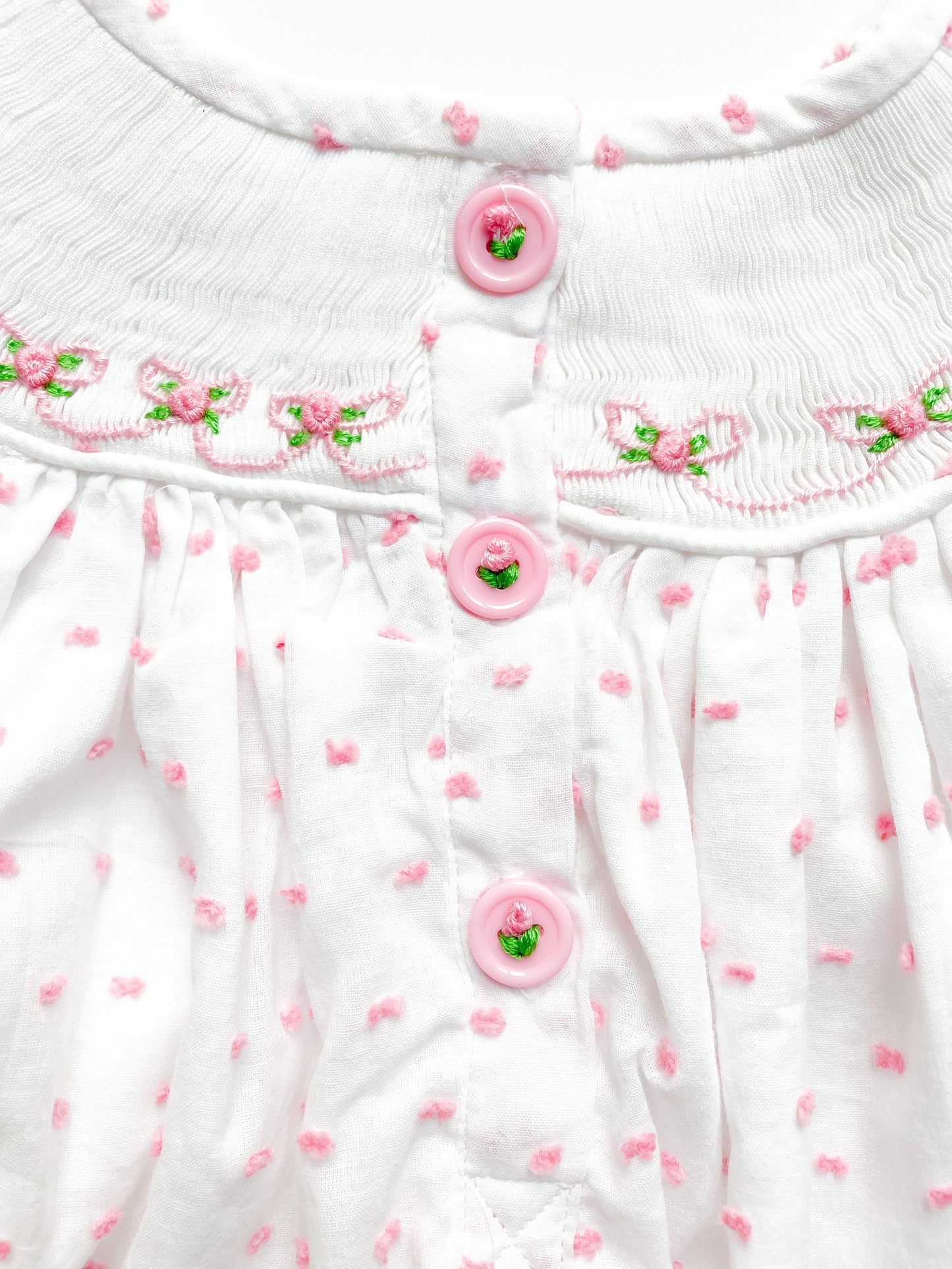 Pink buttons on back of little sister bubble, adorned with pink flowers